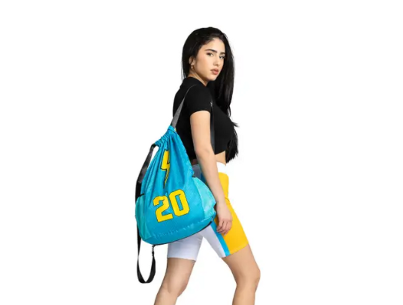 a young adult female with a blue and yellow shoulder bag draped over her shoulder