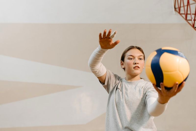a young female practicing hitting a volleyball