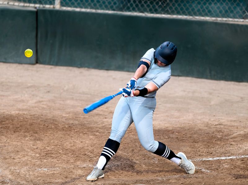 a softball player hitting a softball pitch