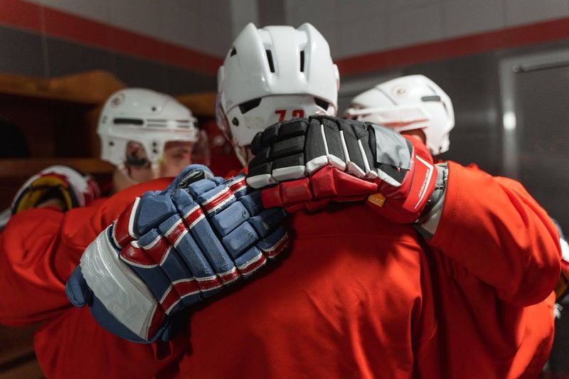 a group huddle of hockey players in a locker room