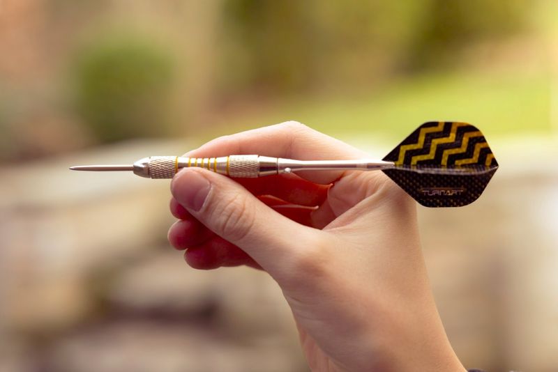 a close up photo of a hand holding a dart