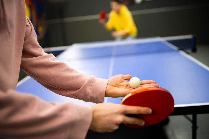 a ping pong player about to serve a ping pong to an opponent