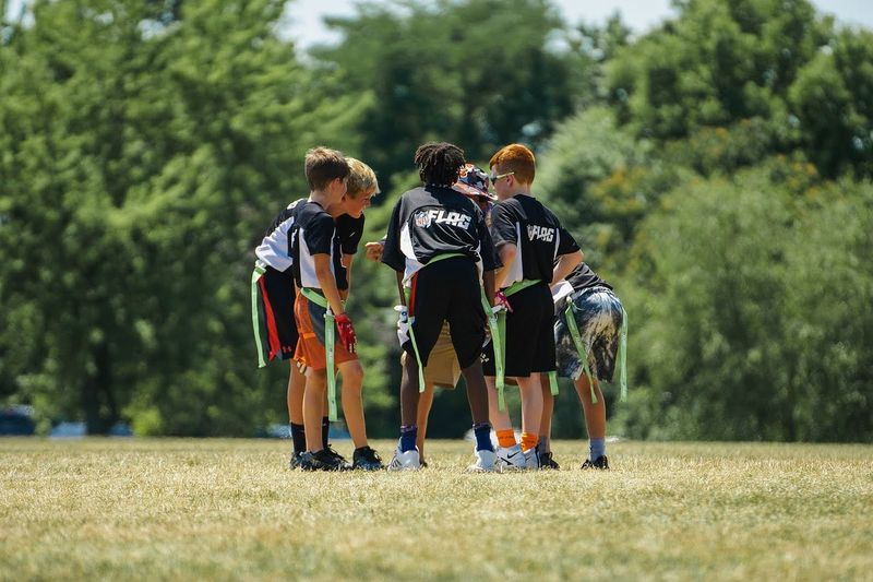 a youth flag football team in a huddle