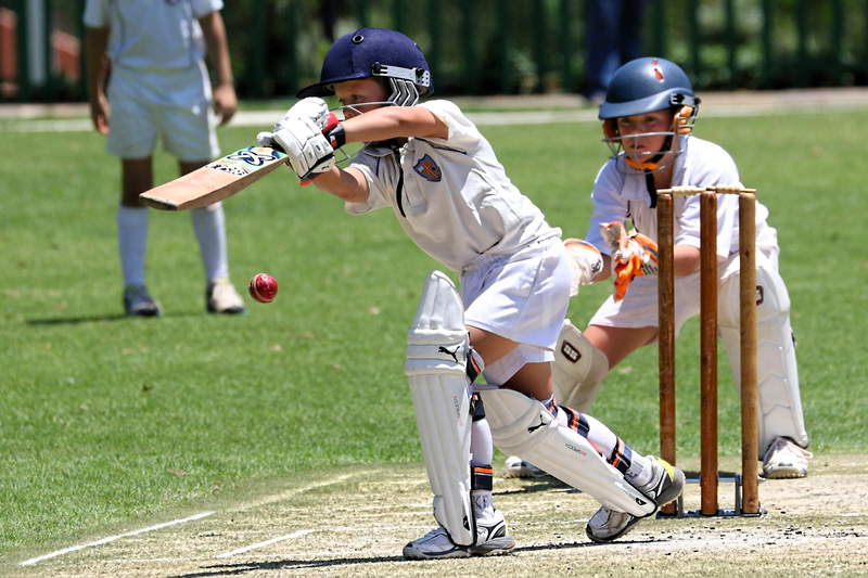 a youth cricket player hitting a cricket ball
