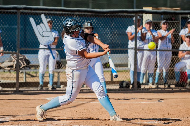 a softball player batting a softball pitch