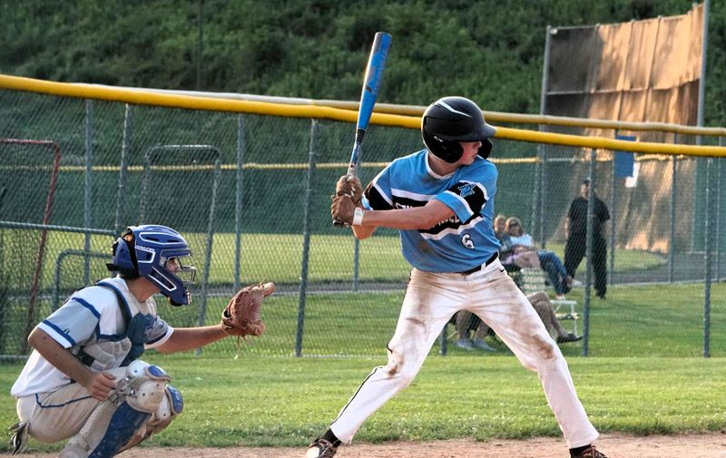 a youth baseball player batting a baseball