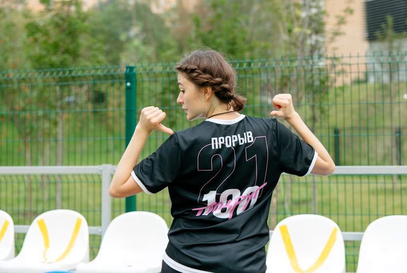 female wearing a jersey pointing to her jersey number