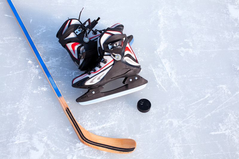 hockey equipment laying on an ice rink