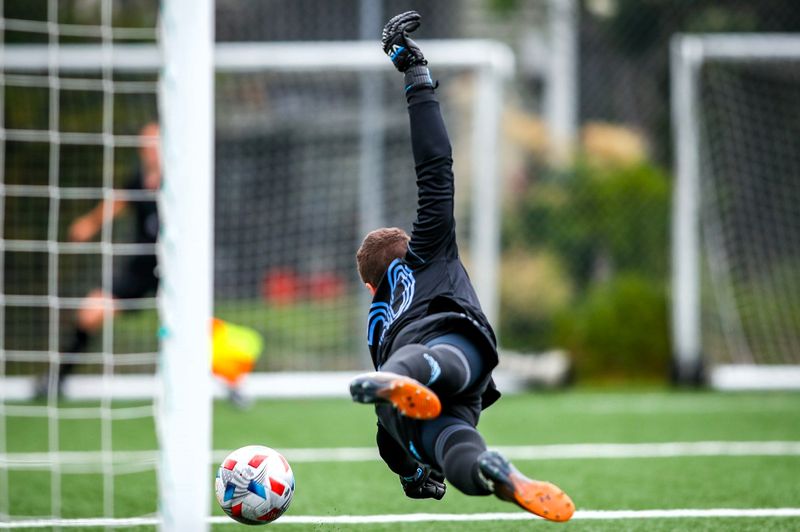 a soccer goalie diving to block a shot