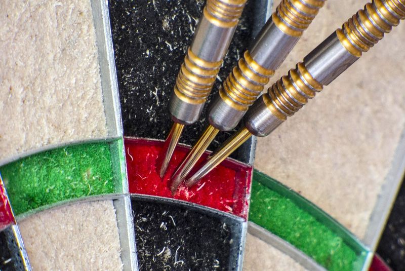 three darts in a triple twenty position on a dart board