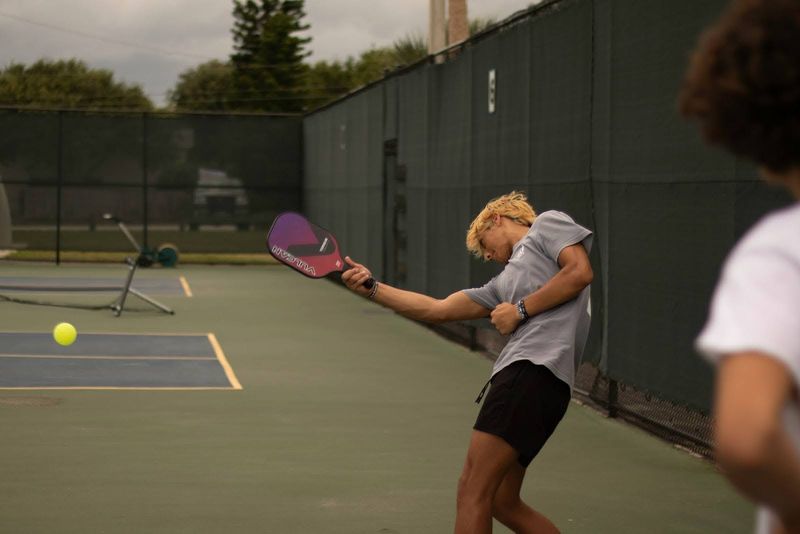 a male pickleball player swinging at the ball