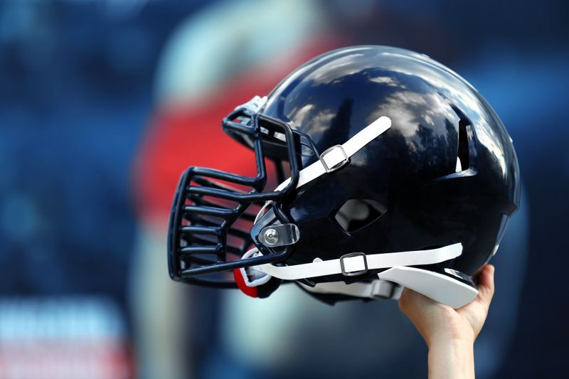 a hand holding a black football helmet