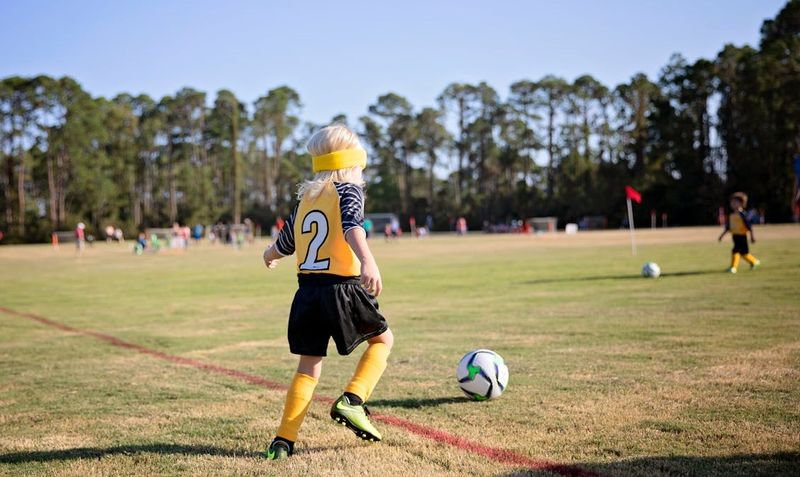 a young girl about to kick a soccer ball