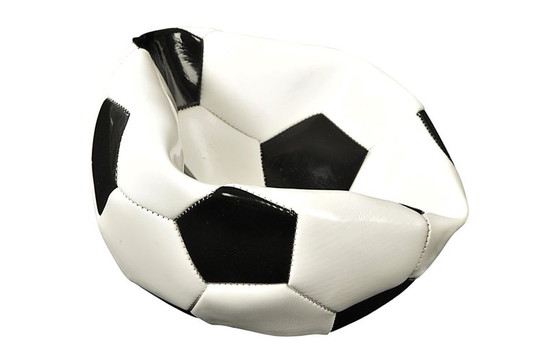 a deflated white and black soccer ball against a white background