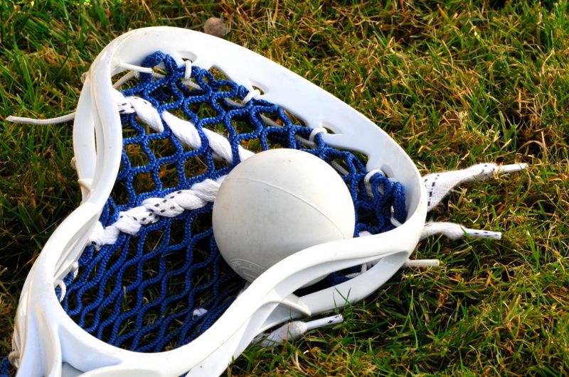 a lacrosse racket and lacrosse ball on grass