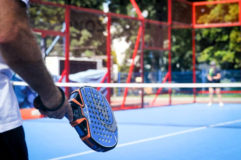 two people playing padel on an outdoor court