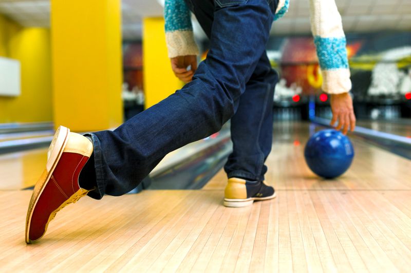 a male adult bowling a bowling ball