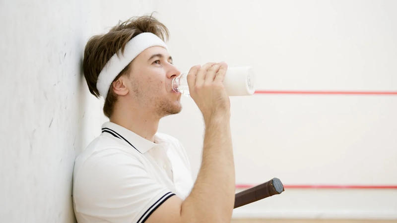 a man drinking from a sports water bottle