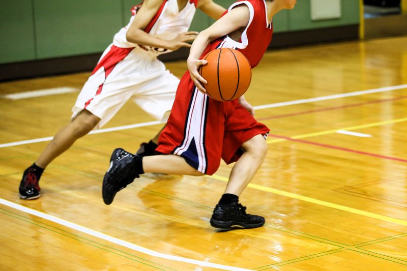 two basketball players on a basketball court wearing red and white uniforms