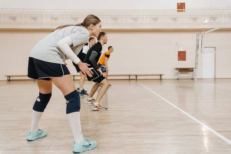 A volleyball team preparing to defend a spike ball