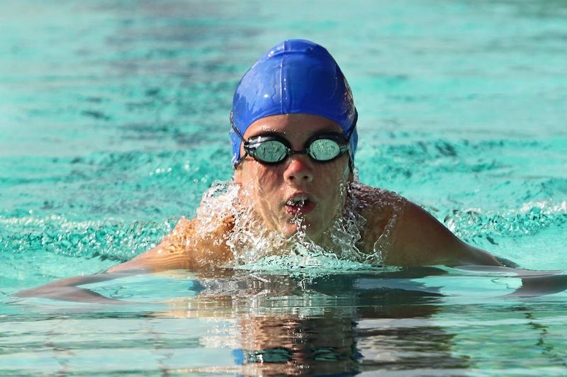 a young swimmer wearing a swim cap and goggles