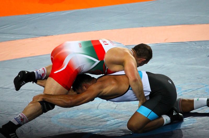 two wrestlers wrestling on a wrestling mat