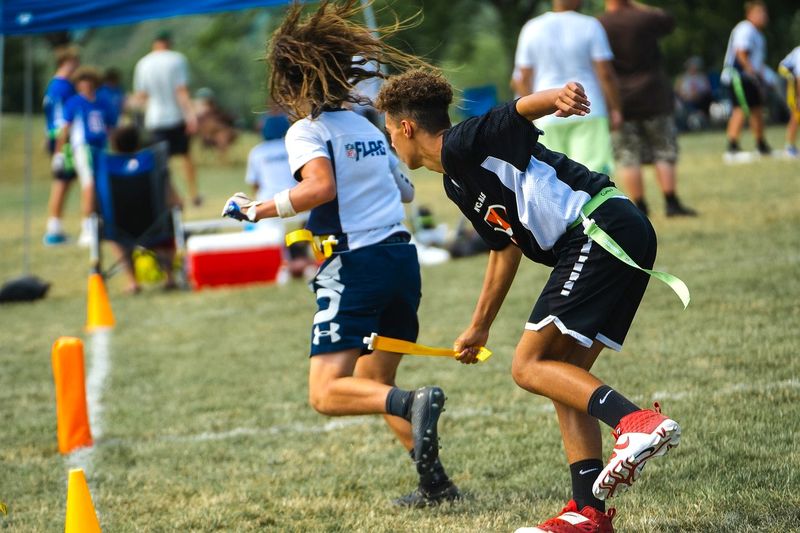 a flag football player grabbing a flag from an opponents belt