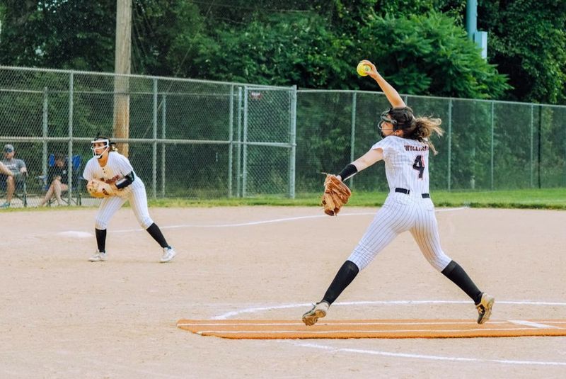 a female softball player pitching a softball