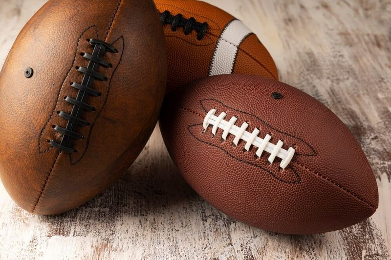 an image of three different styles of American footballs