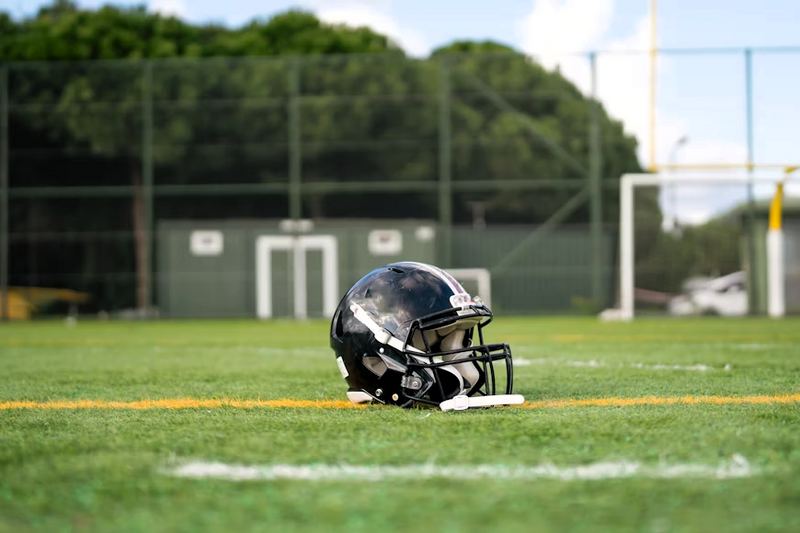a black football helmet placed on a football field
