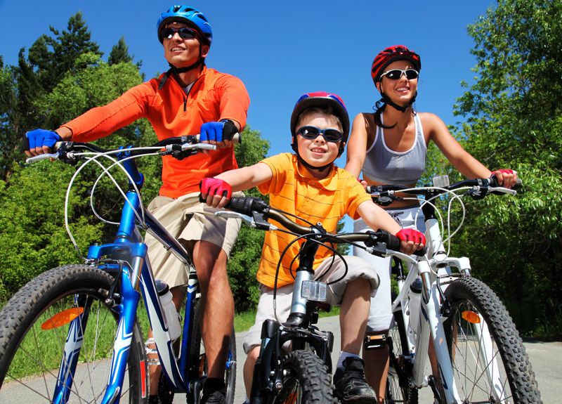 a family of cyclists donning safety gear