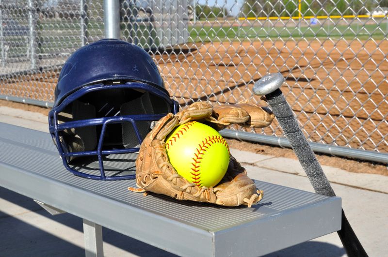 softball equipment sitting on a bench
