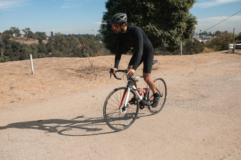 a cyclist riding a bicycle on a dirt trail