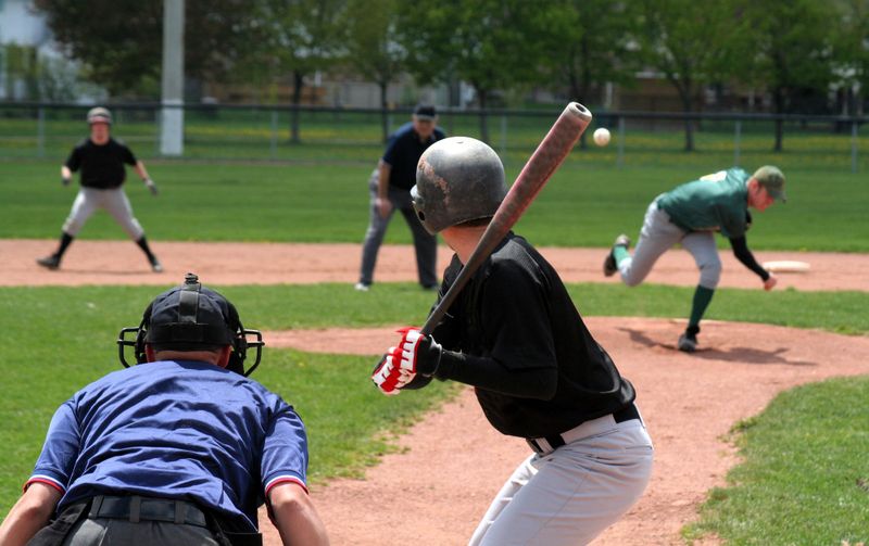 a baseball hitter about to receive a baseball pitch