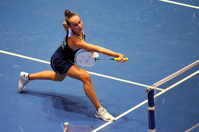a female badminton player hitting a shuttlecock across the net