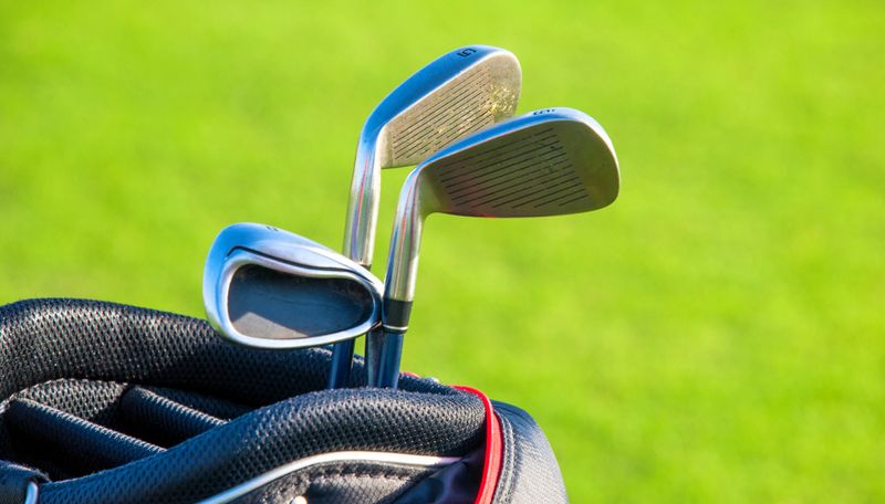 three golf irons in a golf bag