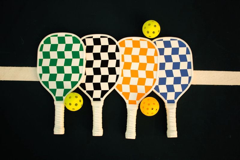 a set of checkered pickleball paddles and pickleballs