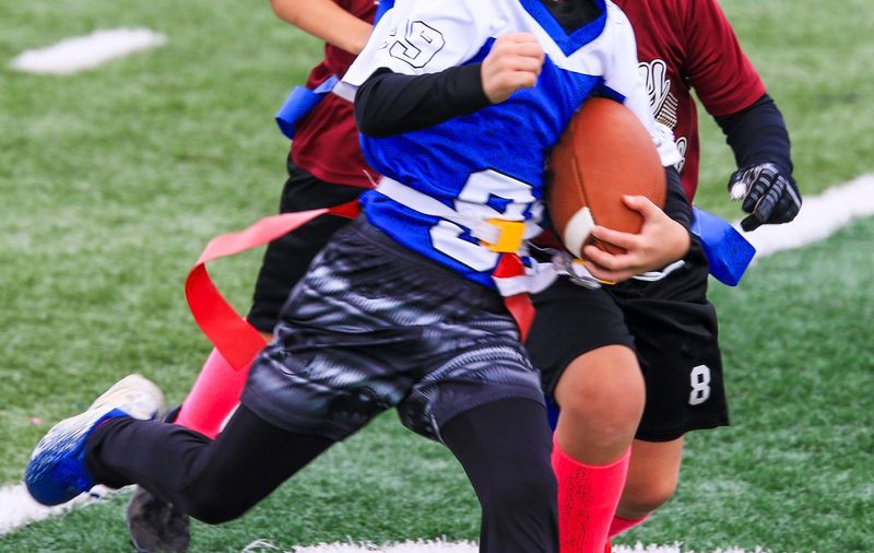 flag football player running with a football