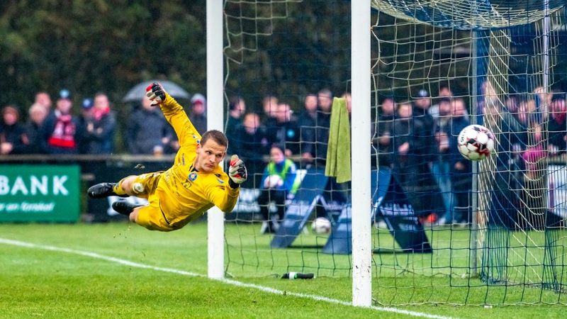 a soccer goalkeeper diving to save a shot